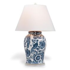 a blue and white vase with a lamp on it