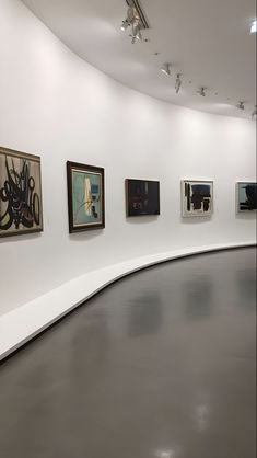 an empty room with paintings on the wall