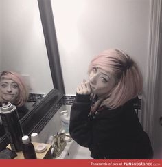 two women in front of a mirror with their faces painted to look like they are brushing their teeth