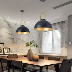 a dining room table with chairs and two lights hanging from it's ceiling over it