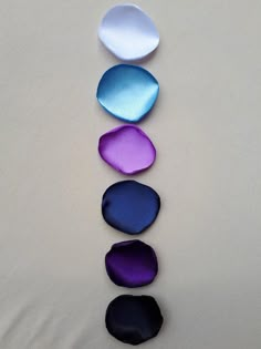 five different shades of blue, purple, and white are arranged in the shape of pebbles