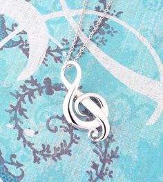 a silver treble necklace on a blue background