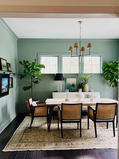 a dining room with green walls and chairs