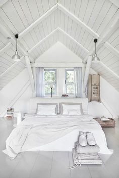 an attic bedroom with white walls and flooring