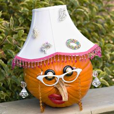 a pumpkin wearing glasses and a hat on top of a wooden table next to bushes