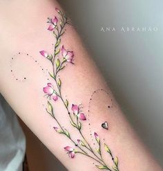 a woman's arm with pink flowers and leaves on the left side of her arm