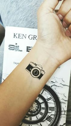 a person with a camera tattoo on their arm