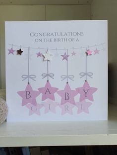 congratulations on the birth of a baby girl with pink stars hanging from clothes pegs