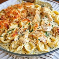 a plate full of pasta with chicken and parmesan cheese on the top is ready to be eaten