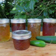 jars filled with pickles and sauces sitting on a cutting board