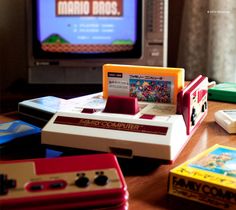 an old nintendo game console sitting on top of a wooden table next to a tv