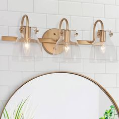 a bathroom light with three lights on it and a round mirror in front of it