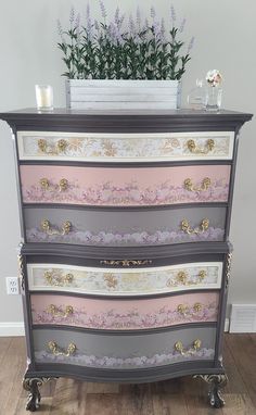 an old dresser has been painted pink and grey with gold trimmings on it