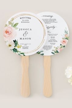 two wooden paddles with floral designs on them and the names of their wedding guests