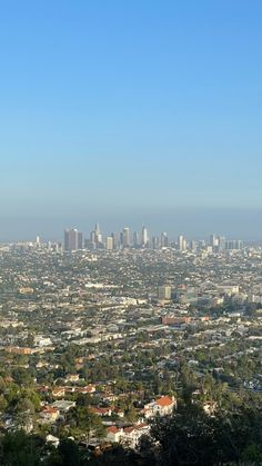 a view of the city from atop a hill with trees and buildings in the background