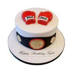 a birthday cake with two red boxing gloves on top