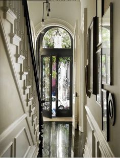 an entry way leading to a house with black and white decor on the walls, doors and stairs