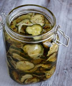 pickled cucumbers in a glass jar on a wooden table