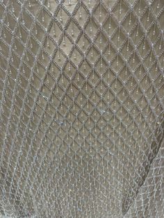 Add elegance and sparkle to your creations with this luxurious silver crystal drop sequin beaded net fabric. The delicate lattice design, made from high-quality polyester netting, is intricately adorned with crystal beads that catch the light beautifully, offering a stunning shimmer effect. IMPORTANT DETAILS: Width: 120cm Color: White base with silver crystal embellishments Material: Durable polyester net with hand-applied crystal beads Origin: Crafted in India, known for its exquisite beadwork Wedding Dress Luxury, Fabric Wedding Dress, Haute Couture Fabric, Beaded Fabric, High Fashion Accessories, Mesh Fashion, Beading Netting, Dress Luxury, Net Fabric