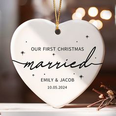 a white heart shaped ornament with the words our first christmas married