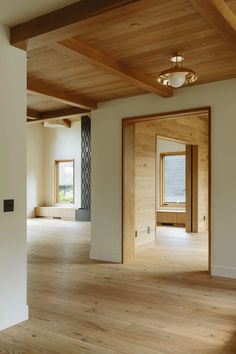 an empty room with wood floors and white walls