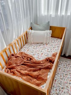 a crib with a blanket and pillows on it