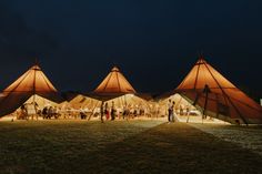 a group of people standing in front of tents at night