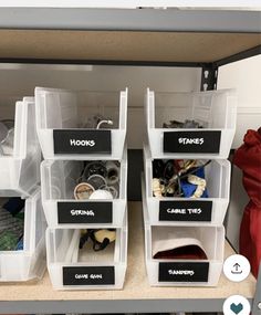 several bins that have labels on them and some shoes are in the bottom shelf