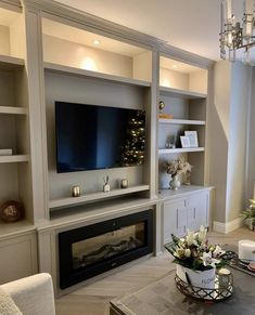 a living room filled with furniture and a flat screen tv mounted on a wall above a fireplace