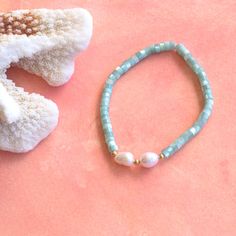 Wearing the Kai bracelet will make you feel like a beach goddess. The pretty shimmering aqua colored shell beads will remind you of tranquil turquoise waters every time you wear it. Wear it alone or stack it with some of our other pretty bracelets. Beautiful aqua shell beads mixed with pearls on a stretch bracelet. Measures approximately 7.5" Summer Beach Pearl Bracelet, Adjustable Beaded Bracelets With Pearl Charm For Beach, Pearl Beaded Bracelets With Pearl Charm For Beach, Beach Beaded Bracelets With Pearl Charm, Beach Pearl Bracelet With Pearl Charm, Summer Pearl Beaded Bracelets For Beach, Bohemian Pearl Bracelets For The Beach, Bohemian Pearl Bracelets For Beach, Turquoise Gemstone Beaded Bracelets For Beach