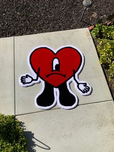 a sticker depicting a heart with arms and legs, on the side of a sidewalk