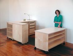 a woman standing next to two wooden desks