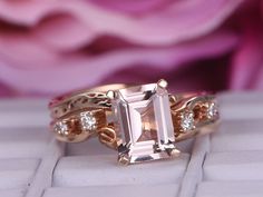 a close up of a ring on top of a white and pink rose flower background