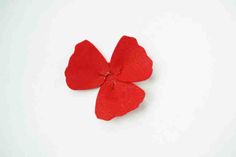 a red felt flower on a white background