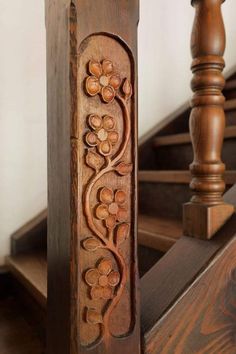 an intricately carved wooden stair rail with flowers on it