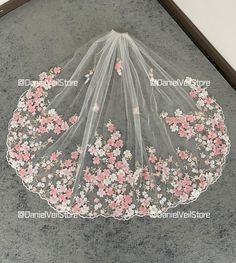 a veil with flowers on it sitting on the floor