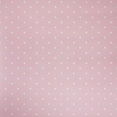 a pink wall with white polka dots on it