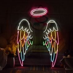 neon angel wings and halo on display in dark room