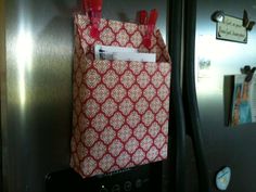 a red and white bag hanging on the side of a refrigerator