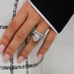 a close up of a person's hand with a diamond ring on their finger