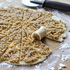 an uncooked pizza sitting on top of a wooden cutting board next to a knife