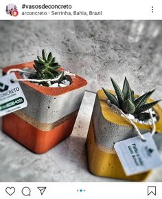 two cement planters sitting on top of a table