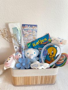 a basket filled with lots of toys on top of a white table next to a wall