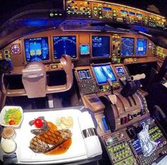 an airplane cockpit filled with lots of different types of food and electronic screens on the walls