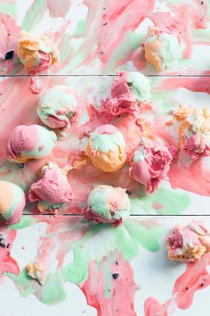 colorful ice cream on white wooden table with pink and green paint splattered all over it