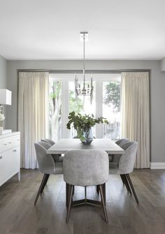 the dining room table is surrounded by gray chairs