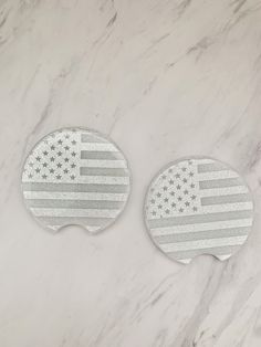 two american flag coasters sitting on top of a marble table