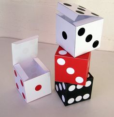 three dice boxes stacked on top of each other, one with black and white polka dots