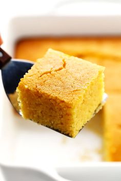 a piece of cornbread on a white plate with a fork