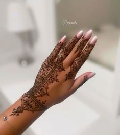 a woman's hand with henna tattoos on it